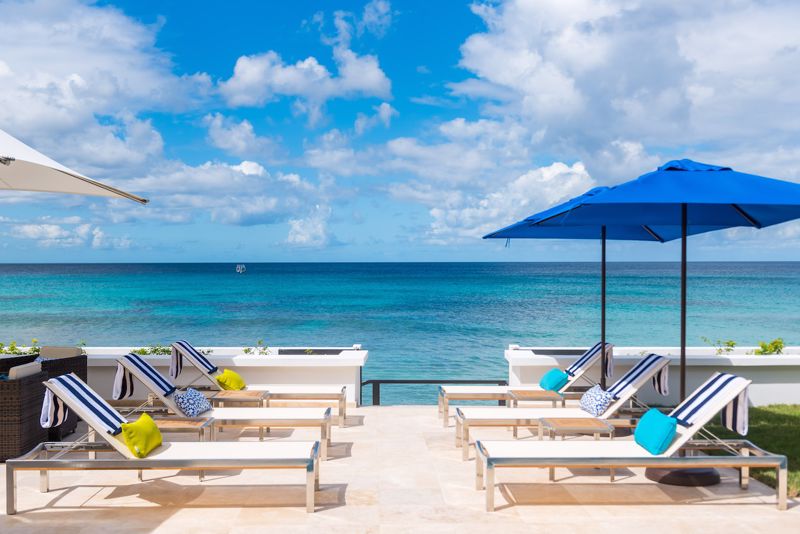 Setting up sales viewings View of sunloungers and the Caribbean sea and sky at beachfront Barbados villa, Nirvana.